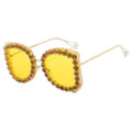 Sunglasses with yellow lenses and decorative frame on a white background