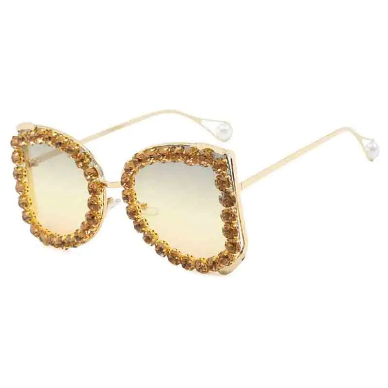 Gold-framed sunglasses with rhinestone embellishments on a white background
