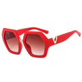 Red sunglasses with gold accents on a white background