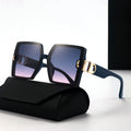 Sunglasses with black frame and gold accents on a black case against a white background