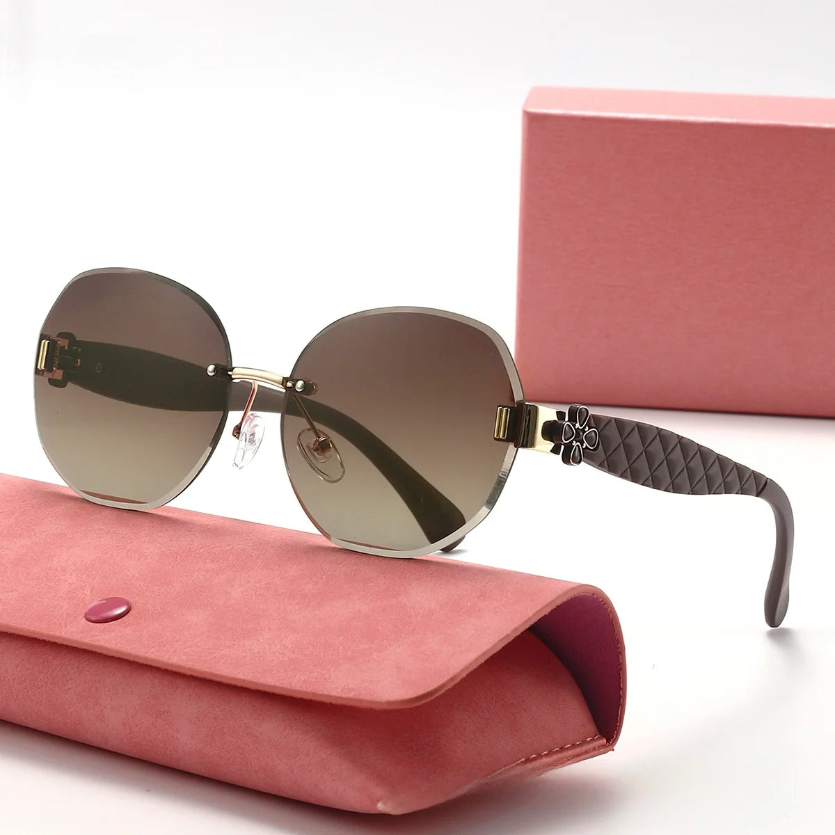 Sunglasses with quilted arm design on a pink case with a pink box in the background