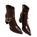 Pair of brown leather boots with gold buckles on a white background