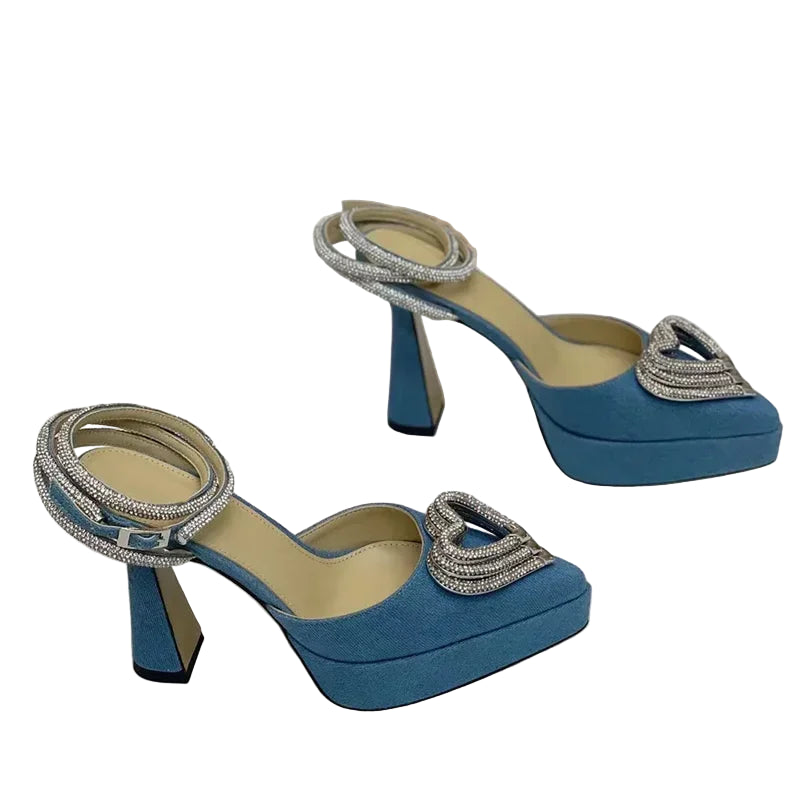 Blue high-heeled shoes with decorative straps on a white background