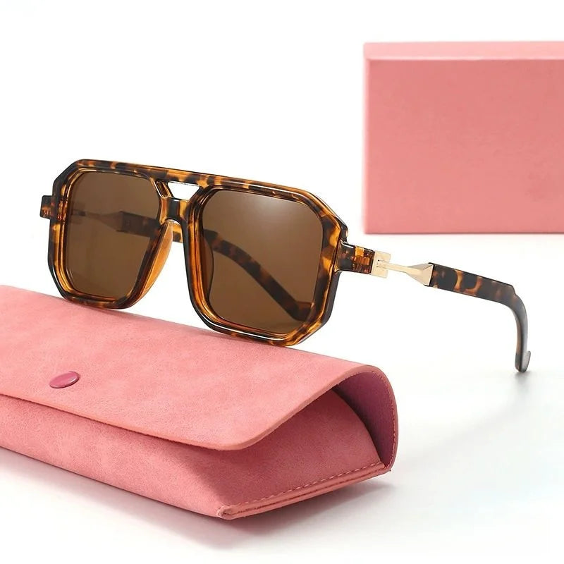 Tortoiseshell sunglasses with brown lenses on a pink case against a white background
