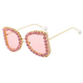 Sunglasses with pink lenses and gold frame on a white background