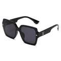 Black sunglasses with a golden V decorative arm on a white  background