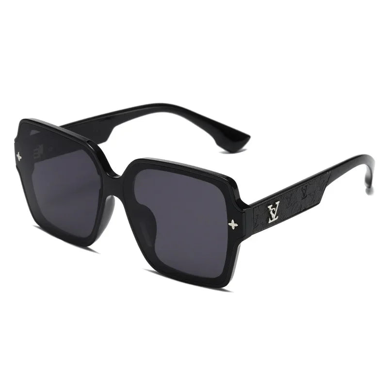 Black sunglasses with a golden V decorative arm on a white  background