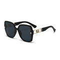 Black sunglasses with gold accents on a white background