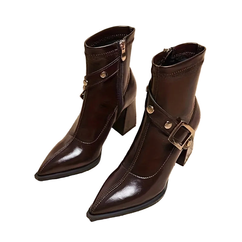 Pair of brown leather boots with gold buckles on a white background