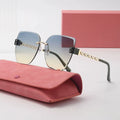 Sunglasses with gradient lenses and gold frame on a pink case with a pink box in the background.