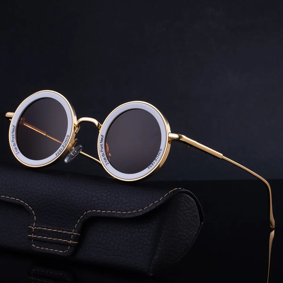 Round sunglasses with tortoiseshell frame and brown lenses on a white background