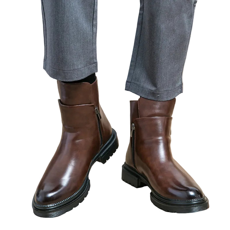 Brown leather boots worn with gray pants on a white background