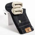 Black denim jeans with beige sherpa lining on a white stool