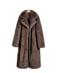 Brown fur coat hanging on a hook against a white wall.