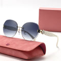 Sunglasses with quilted strap on a pink case with a pink box in the background