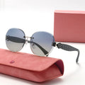 Sunglasses with gray gradient lenses and quilted arm design on a pink case with a matching box.